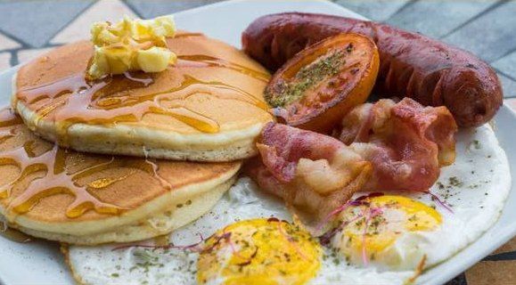 English breakfast with pancakes, sausage and eggs