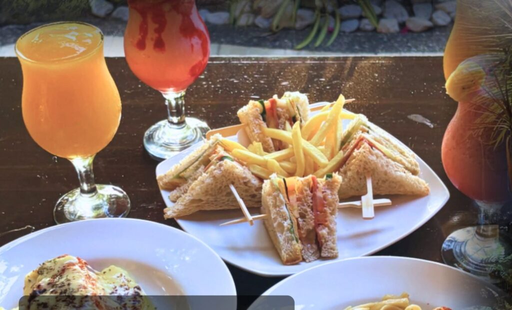 A shared table of sandwiches, pasta and coolers